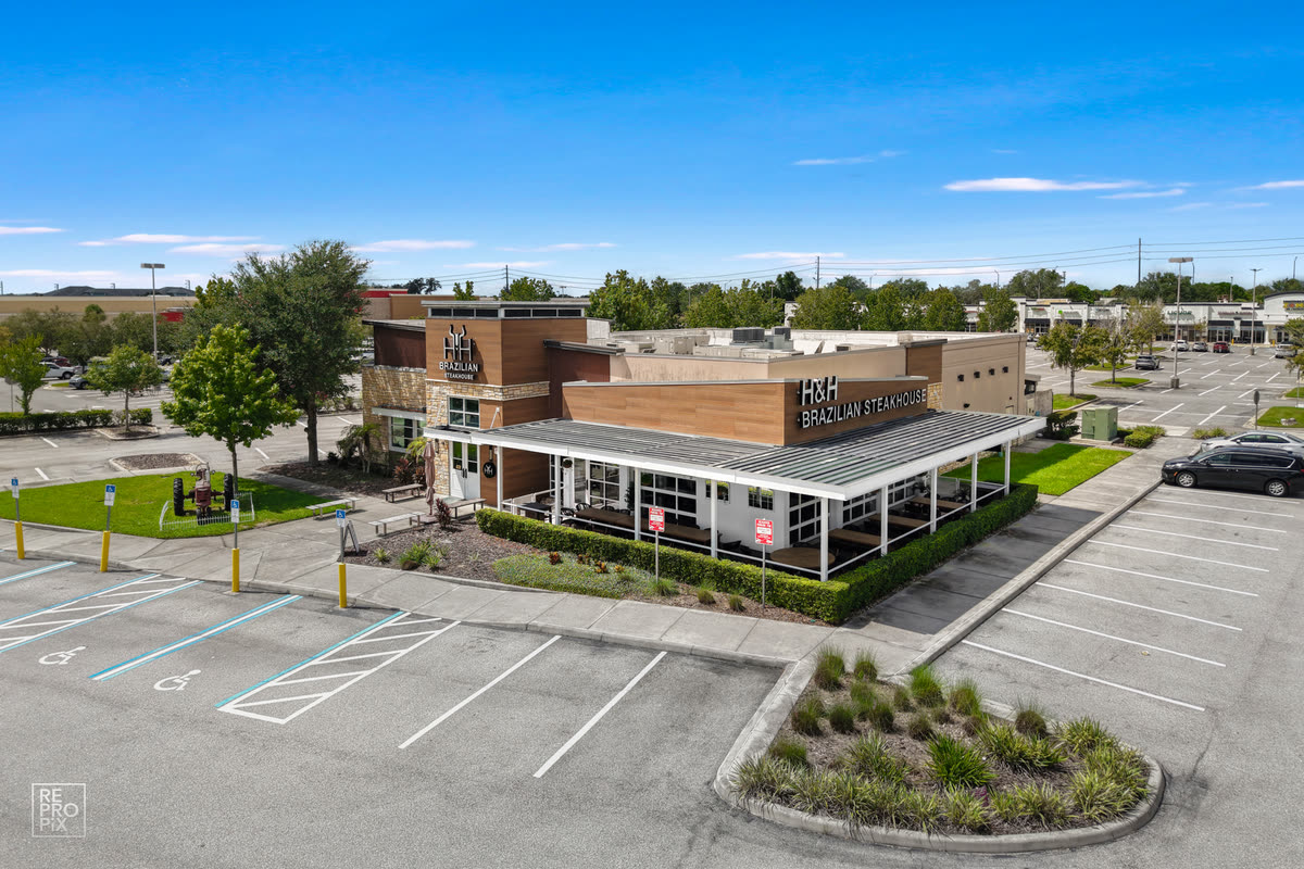 Aerial view of a single-story retail building and its parking lot — commercial drone photography