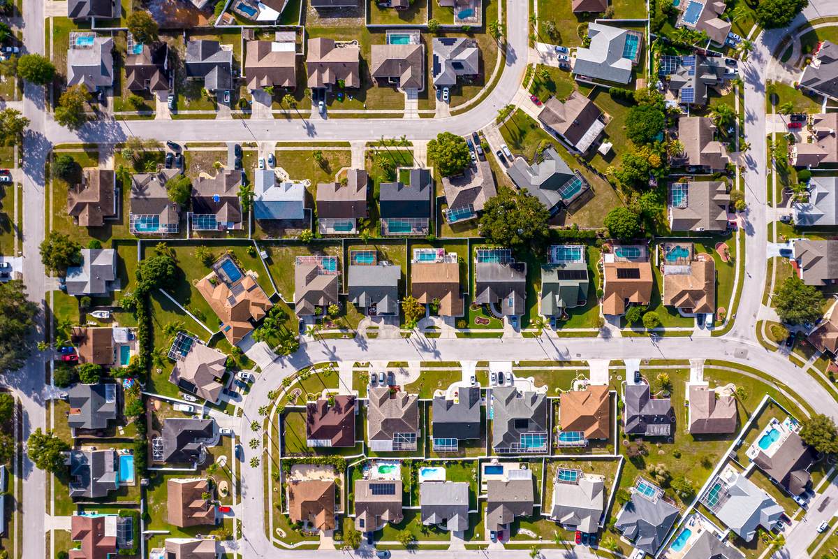 Aerial view of a suburban neighbourhood with screened pools and curving streets