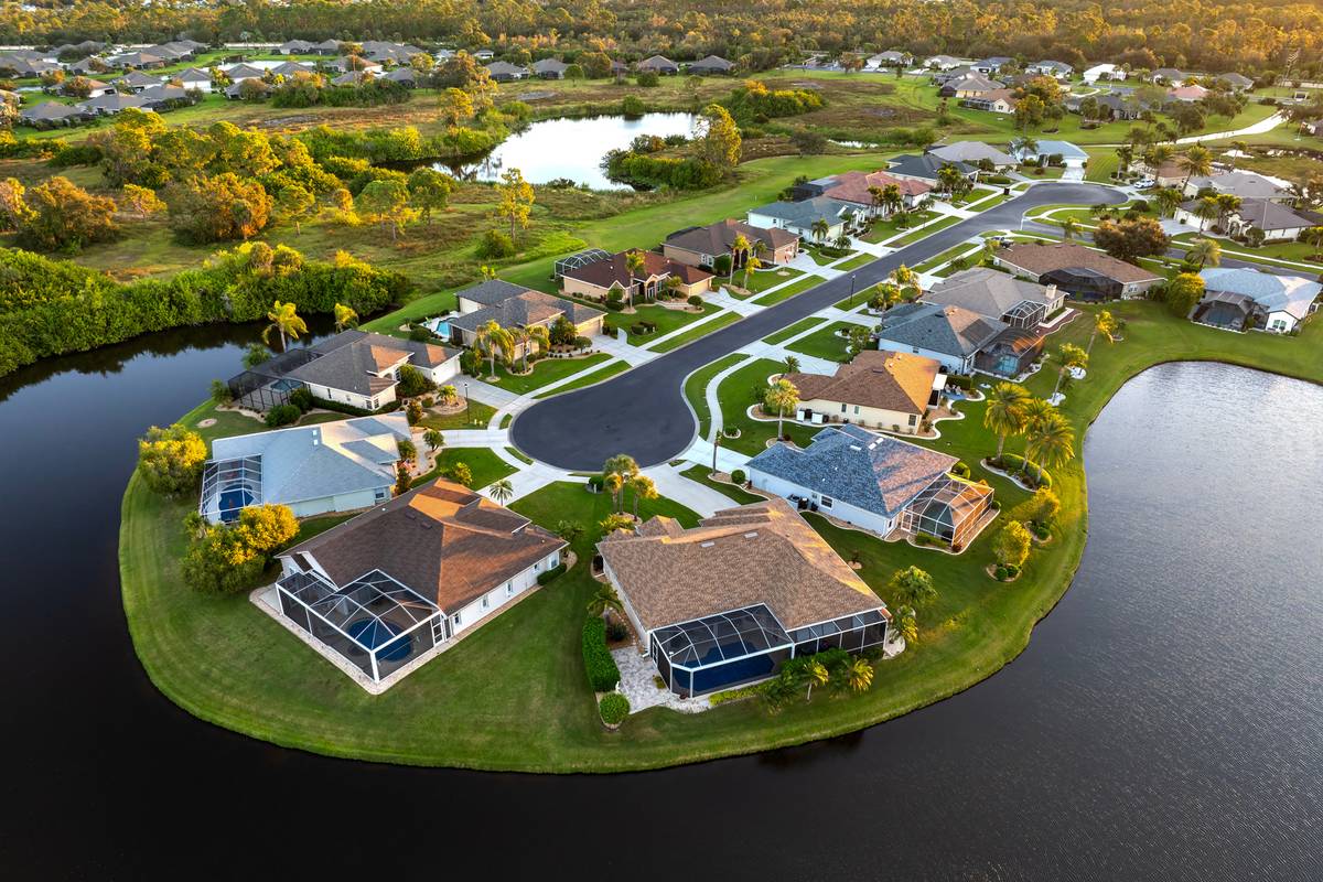 Aerial view of waterfront homes on a landscaped peninsula surrounded by canals