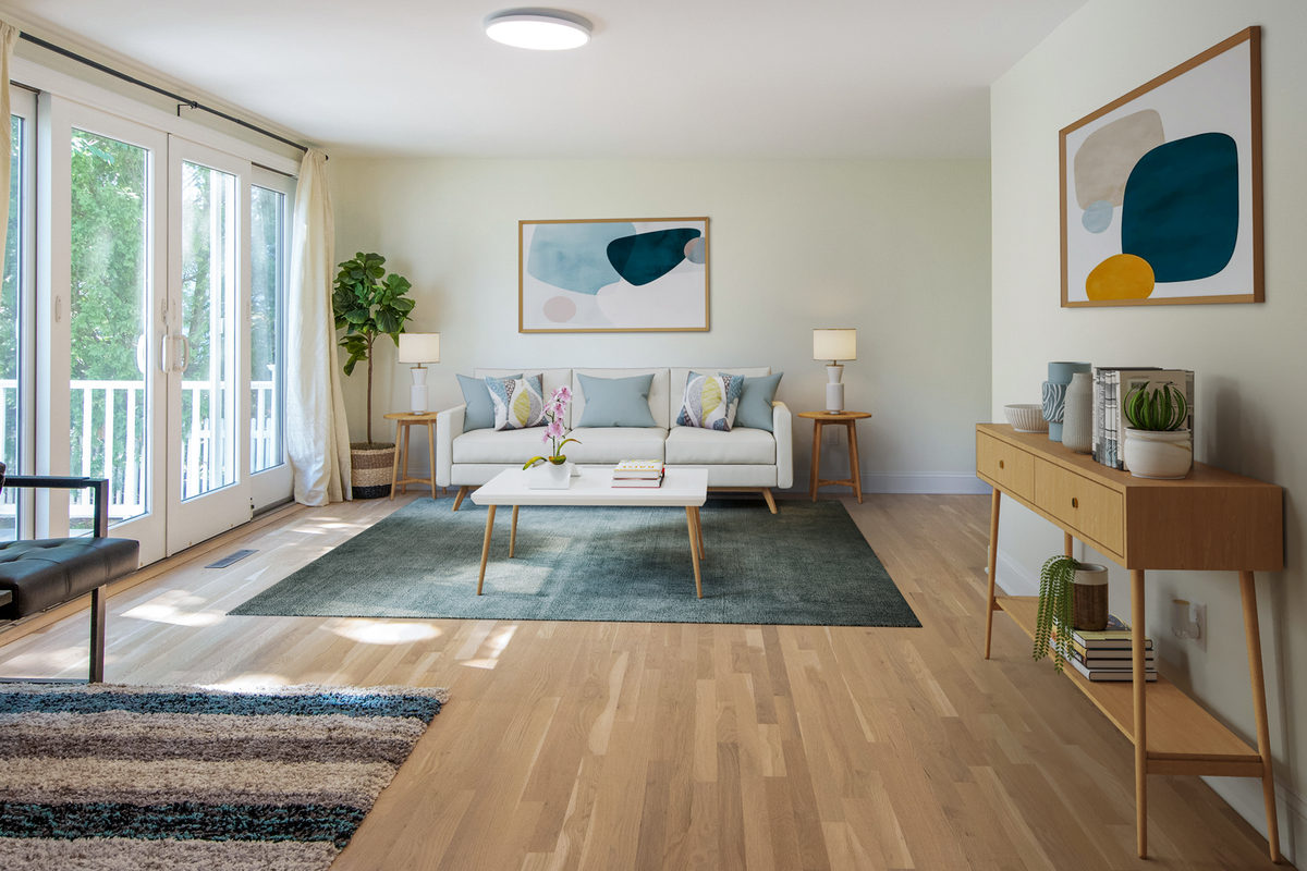 Staged living room with a sofa, console table and glazed doors to a balcony