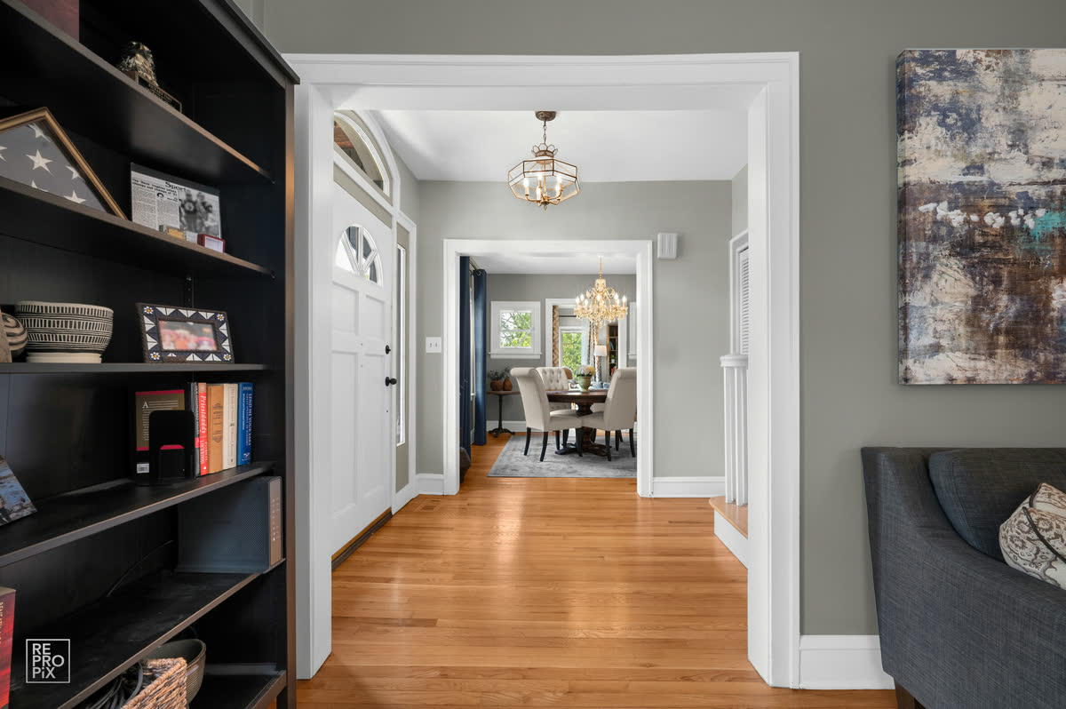 Entry hall with dark built-in shelving opening through to the dining room — home interior photography