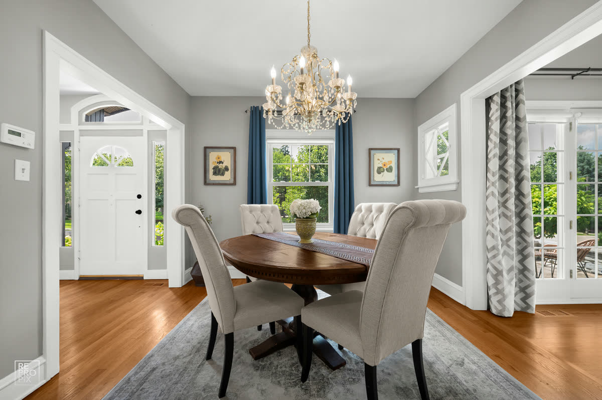 Dining room with a crystal chandelier beside the front entry — real estate photography