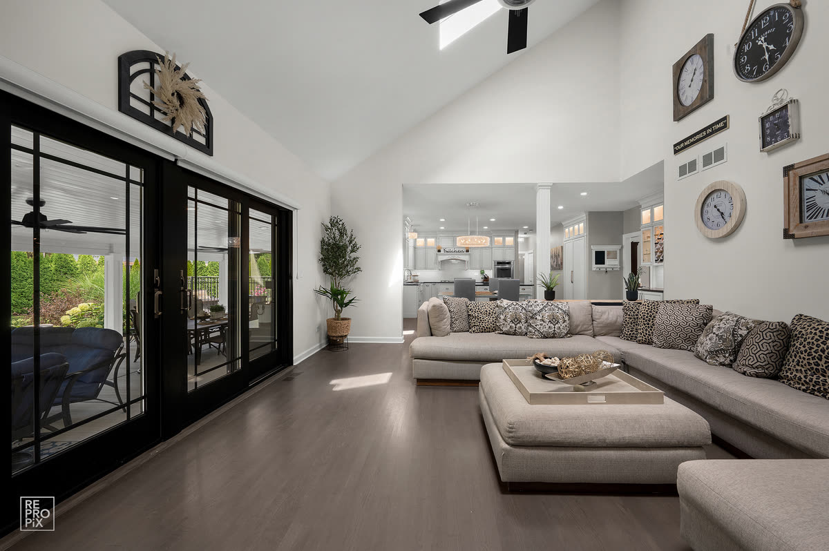 Vaulted living room with a large sectional and black sliding doors onto the patio — home interior photography